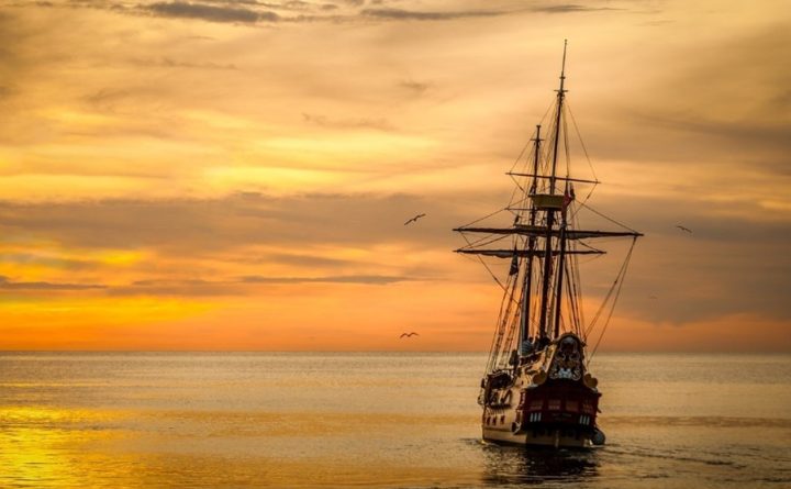 Image of a sailboat navigating out in the ocean after a storm.