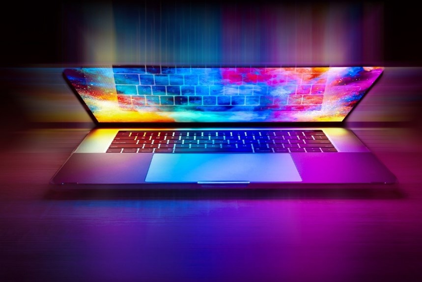 Image of a laptop with a colorful array illuminating from it.